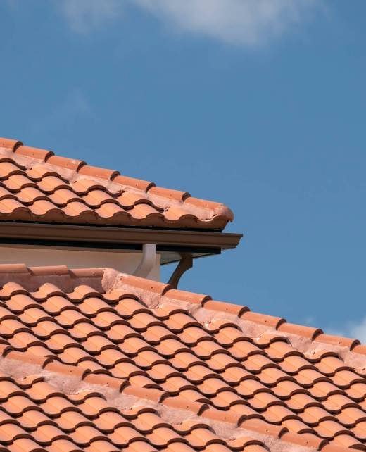Overlapping rows of yellow ceramic roofing tiles covering residential building roof in southern Florida Overlapping rows of yellow ceramic roofing tiles covering residential building roof in southern Florida.